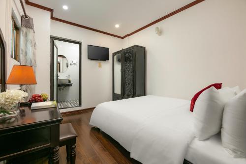 a bedroom with a white bed and a desk and a mirror at Silk Castle Hotel & Spa - Hanoi Old quarter in Hanoi
