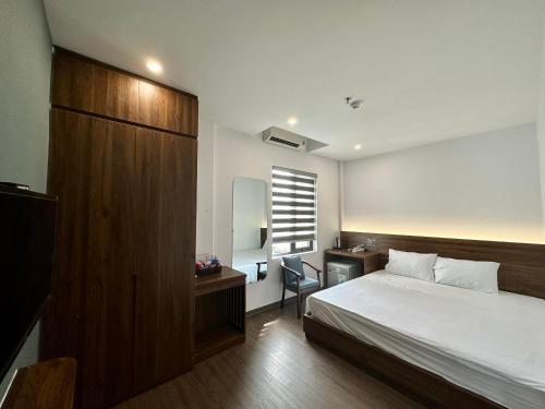 a bedroom with a bed and a desk and a window at Hải Âu Hotel in Xóm Ðé