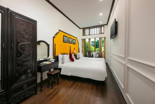 Schlafzimmer mit einem weißen Bett und einem Spiegel in der Unterkunft Silk Castle Hotel & Spa in Hanoi