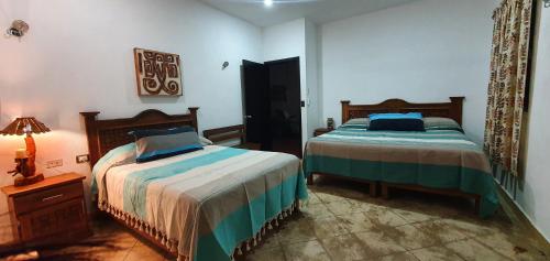 a bedroom with two beds and a lamp on a table at Finca Oz in Homún