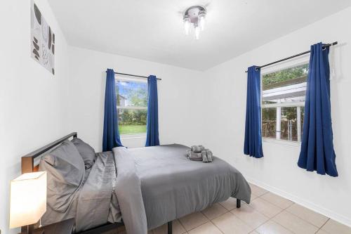 a bedroom with a bed with blue curtains and a window at Spacious 3 Bedroom home in Riverside in Jacksonville