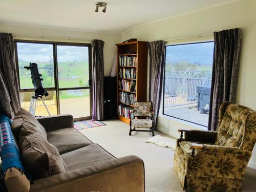 a living room with a couch and a large window at Perma Ridge Farmstay in Ngaruawahia