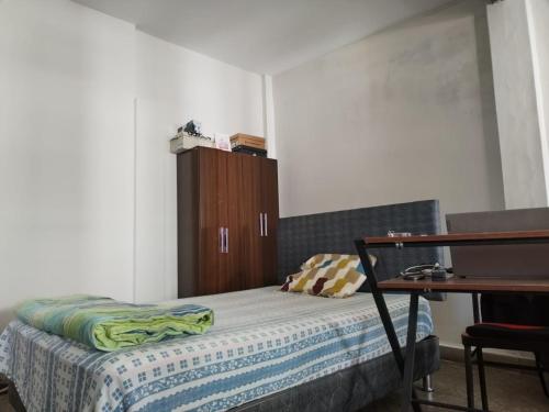 a bedroom with a bed and a wooden cabinet at Piura Eterno Calor in Piura
