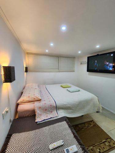 a bedroom with a bed and a flat screen tv at Lomas Suites in La Africana