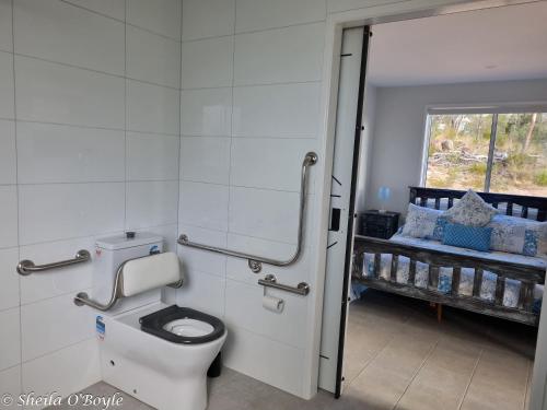 a bathroom with a toilet and a window at Glen Lough Cabins in Glen Aplin