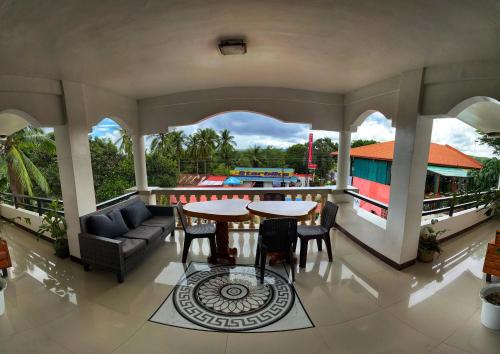 sala de estar con mesa y sillas en el balcón en White Summerville Tourist Inn, en Busuanga