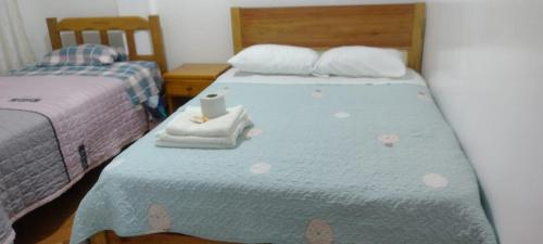um quarto com 2 camas individuais e uma colcha azul em HOSPEDAJE GIMAJA em Villa Rica