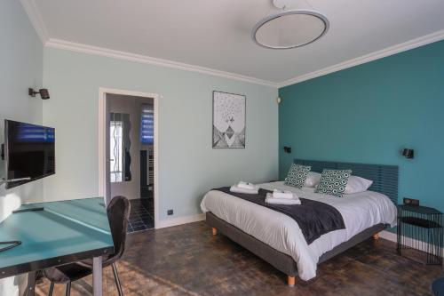 Schlafzimmer mit einem Bett mit blauer Wand in der Unterkunft LES DRYADES MILLY in Milly-la-Forêt