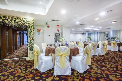 a banquet hall with tables and chairs and flowers at Hotel Sarina in Dhaka