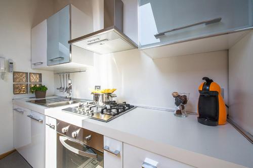 a white kitchen with a stove and a sink at Apartment 23 in Como
