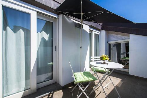 a table and chairs on a balcony with an umbrella at Apartment 23 in Como