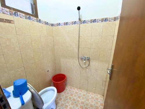 łazienka z prysznicem, toaletą i wiadrem w obiekcie Vila Bumi Rama puncak cisarua w mieście Cisarua