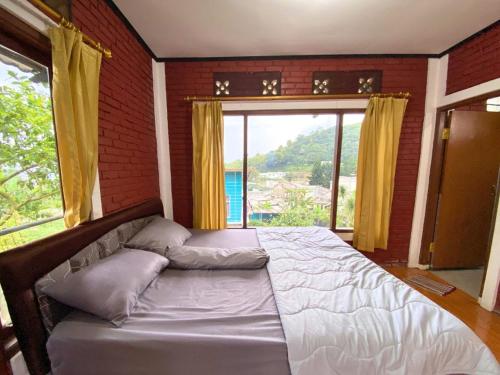 łóżko w pokoju z dużym oknem w obiekcie Vila Bumi Rama puncak cisarua w mieście Cisarua