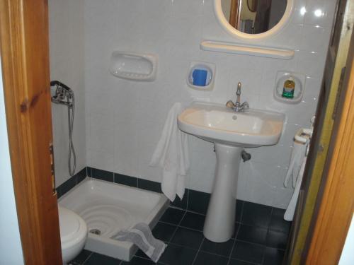 uma pequena casa de banho com lavatório e WC em Youth Ηostel Archipelagos - semi basement studio at Possidonia em Ano Syros