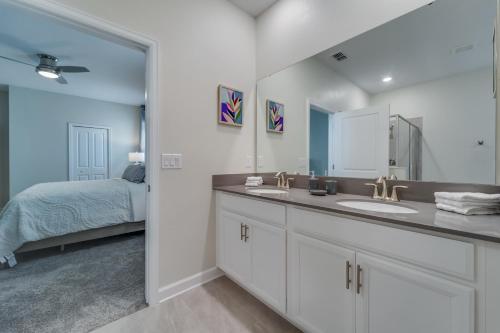 a bathroom with two sinks and a bed in a room at 9 Bedroom Family Friendly Retreat - Private Pool in Kissimmee