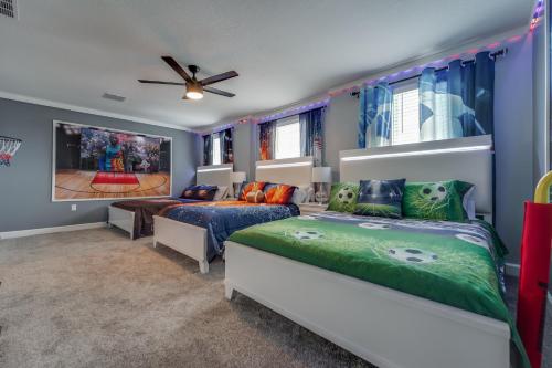 a bedroom with two beds and a ceiling fan at 9 Bedroom Family Friendly Retreat - Private Pool in Kissimmee