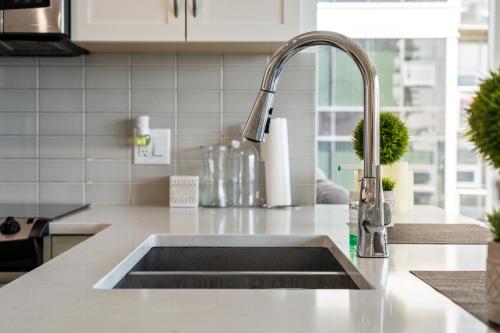 a kitchen counter with a sink in a kitchen at Chic 2BR Condo in Vibrant Downtown Calgary in Calgary