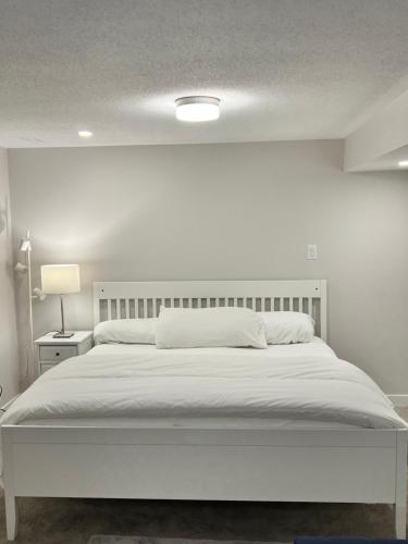 a white bedroom with a large bed with a white headboard at The Oasis Lounge by Luke 1913 in Ottawa