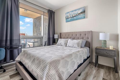 a bedroom with a large bed and a balcony at Chic 2BR Condo in Vibrant Downtown Calgary in Calgary