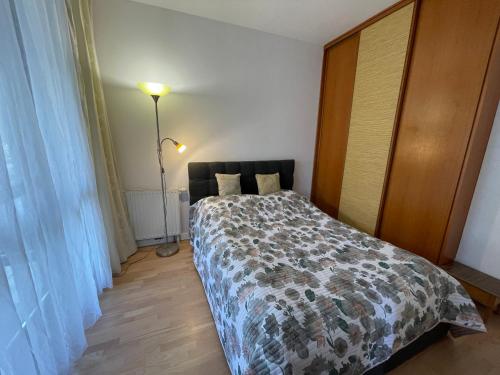 a bedroom with a bed and a lamp at Apartament Dominikański Oliwa in Gdańsk