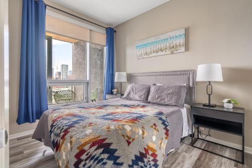 um quarto com uma cama, uma secretária e uma janela em City Centre Retreat - 1BR Condo with Desk em Calgary
