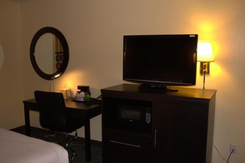a bedroom with a television on a dresser with a desk at Super 8 by Wyndham Colby in Colby