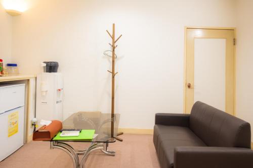 a living room with a couch and a tree at Hotel Lucia at Maebashi Akagi in Maebashi