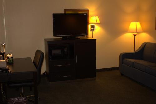 a living room with a tv and a table and a couch at Super 8 by Wyndham Colby in Colby