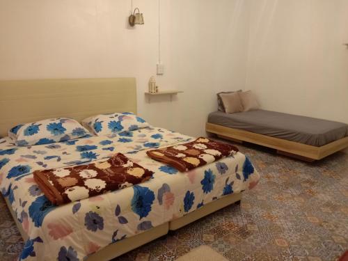 a room with two beds and a bed and a futon at โฮมสเตย์ ยายหนั่น in Ban Nong Kham Tai