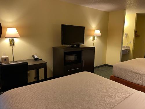a hotel room with two beds and a television at Super 8 by Wyndham Colby in Colby