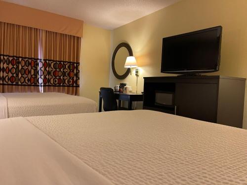 a hotel room with two beds and a flat screen tv at Super 8 by Wyndham Colby in Colby