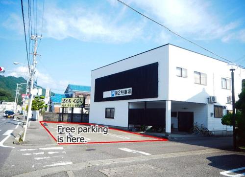 un edificio con una señal de aparcamiento gratuita delante de él en Sushi House, en Shingu