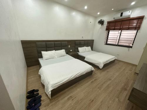 a bedroom with two beds and a window at Khách Sạn Thiên Hương - Thiên hương Hotel 