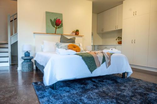 sypialnia z dużym białym łóżkiem z niebieskim dywanem w obiekcie Peaceful Hills Escape: Charming 2-Story Retreat w mieście Upper Sturt