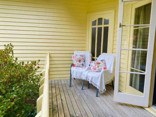two chairs with pillows sitting on a porch at 59 Chaucer Apartment in Cambridge