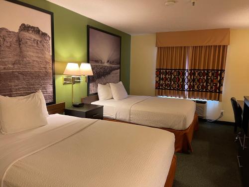 a hotel room with two beds and a window at Super 8 by Wyndham Colby in Colby