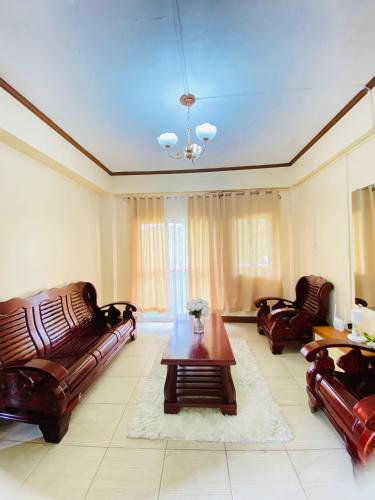 uma sala de estar com sofás de couro e uma mesa de centro em Unit Three Transient Home em Baguio