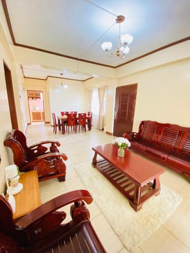 een woonkamer met een bank en een tafel bij Unit Three Transient Home in Baguio