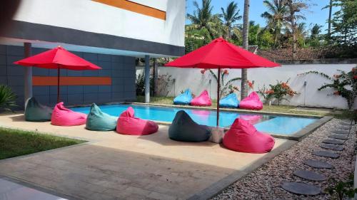 Soda Resort Gili Trawangan في غيلي تراوانغان: مجموعة من الوسائد الملونة جالسة بجوار حمام السباحة