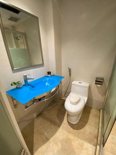 uma casa de banho com um lavatório azul e um WC. em Express Inn Bintulu em Bintulu
