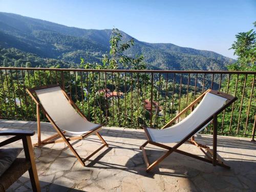 two chairs sitting on a balcony with mountains in the background at Stella's Country House in Prodromos