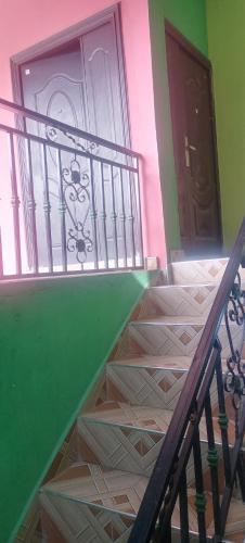 a staircase in a house with a green wall and doors at Executive Lodge in Kasoa