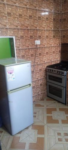a small kitchen with a refrigerator and a stove at Executive Lodge in Kasoa