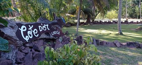 a sign on a rock wall in a park at Hotel Cote d'or Lodge in Baie Sainte Anne