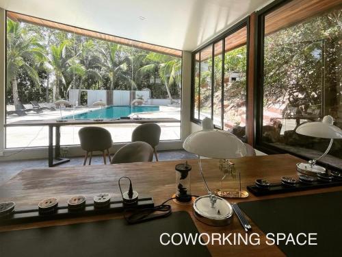 a dining room with a table and a swimming pool at Tantawan sea view residence 山海居 in Salad Beach