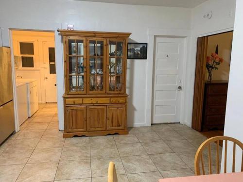 una cocina con un armario de porcelana de madera en una habitación en EL Cerrito Home - Private Rooms with Shared Bathroom near Berkeley SFO, en El Cerrito