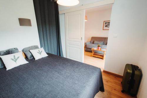a bedroom with a bed and a couch at Vacancéole - Le Domaine de la Vallée d'Ax in Ax-les-Thermes