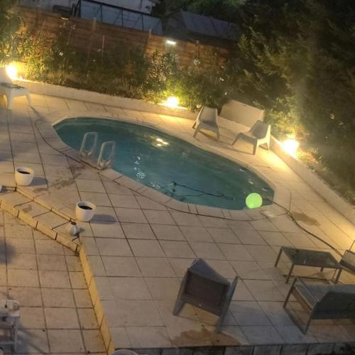 - une piscine avec des chaises et un ballon vert dans l'établissement Villa NathAlain, à Gignac-la-Nerthe