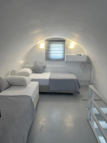 a white room with two beds and a window at Ageri Suite in Vóthon