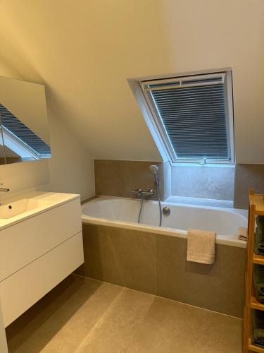 baño con bañera y ventana en Villa Marguerite, en Ostende